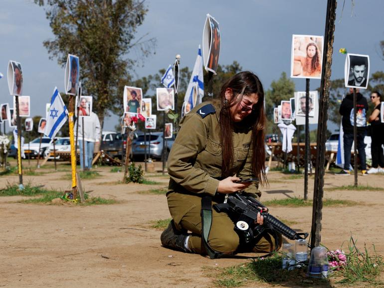 An IDF member next to a memorial of her family members at the site of the Nova festival. A UN team now believes sexual violence occurred in Hamas’s attacks on October 7.