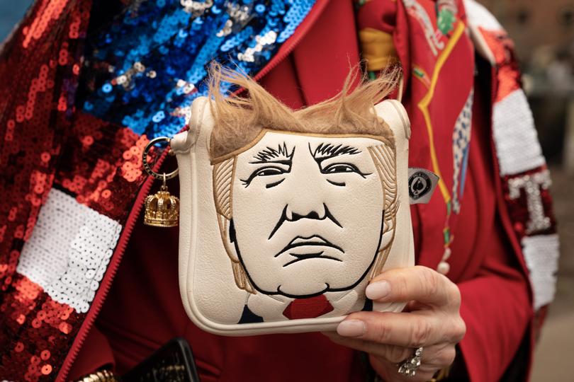  An attendee holds a handbag decorated with former President Donald Trump’s likeness, before a scheduled rally in Rome, Ga. on March 9, 2024.