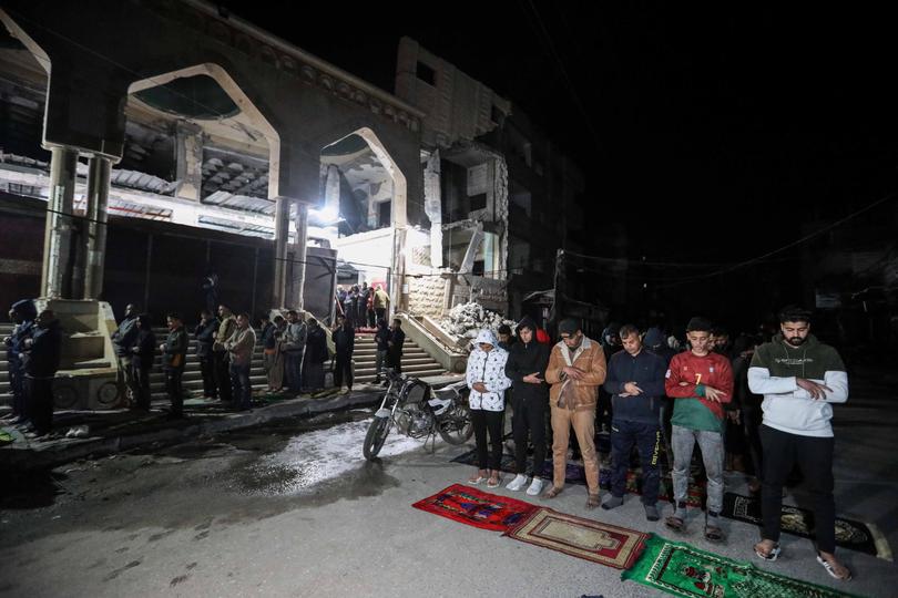 RAFAH, GAZA - March 11: Palestinian citizens perform Tarawih prayers on the first day of the holy month of Ramadan on the rubble of Al-Huda Mosque, which was partially destroyed by Israeli air strikes on March 11, 2024 in Rafah, Gaza. The United States and other nations mediating Israel-Hamas ceasefire talks had hoped to reach a temporary truce prior to the start of the Islamic holy month, but recent meetings in Cairo did not produce a result. Meanwhile, the humanitarian situation remains dire in Gaza, with foreign nations proposing new ways to increase aid deliveries, such as the creation of a temporary port. (Photo by Ahmad Hasaballah/Getty Images)