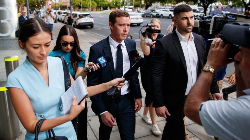 Rohan Dennis (centre) remained silent throughout proceedings in Adelaide Magistrates Court. (Matt Turner/AAP PHOTOS)
