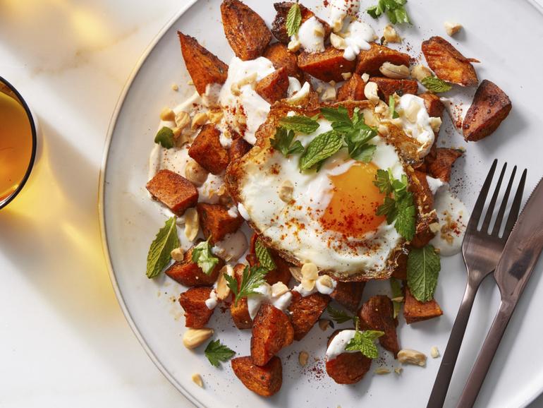 Smoky sweet potatoes with fried eggs and almonds. Melissa Clark adds eggs, almonds and warming spices to a 2011 dish for a lifting, smoky meatless meal. Food Stylist: Simon Andrews. (Christopher Simpson/The New York Times)