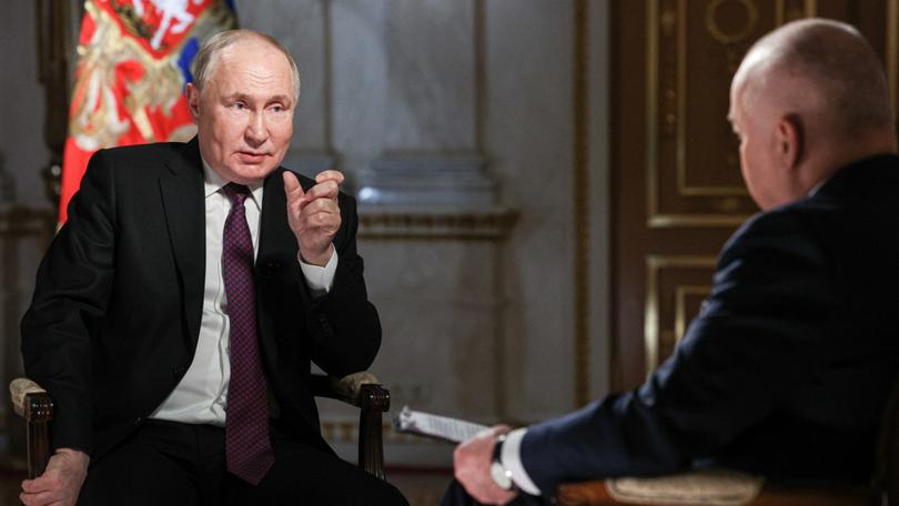Russia’s President Vladimir Putin (L) gives an interview to Rossiya Segodnya media group general director Dmitry Kiselev.  