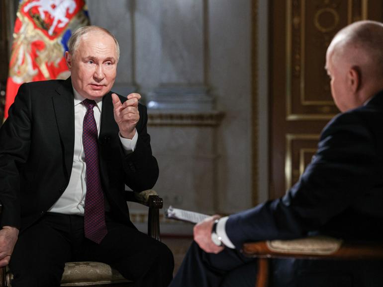 Russia’s President Vladimir Putin (L) gives an interview to Rossiya Segodnya media group general director Dmitry Kiselev.  