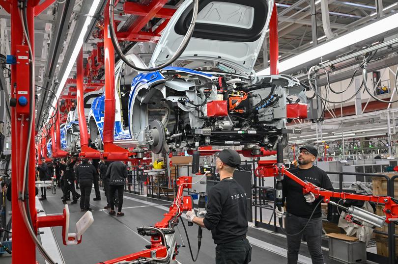 20 March 2023, Brandenburg, Grünheide: Employees of the Tesla Gigafactory Berlin Brandenburg work on a production line of a Model Y electric vehicle. The Tesla plant was opened and put into operation on March 22, 2022. In the meantime, about 10,000 people are employed there. Photo: Patrick Pleul/dpa (Photo by Patrick Pleul/picture alliance via Getty Images)