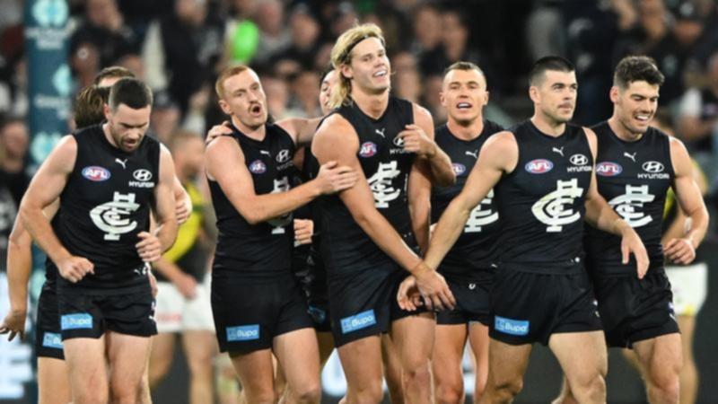 Carlton's Tom de Koning (centre) is congratulated by teammates after a goal against Richmond. (James Ross/AAP PHOTOS)