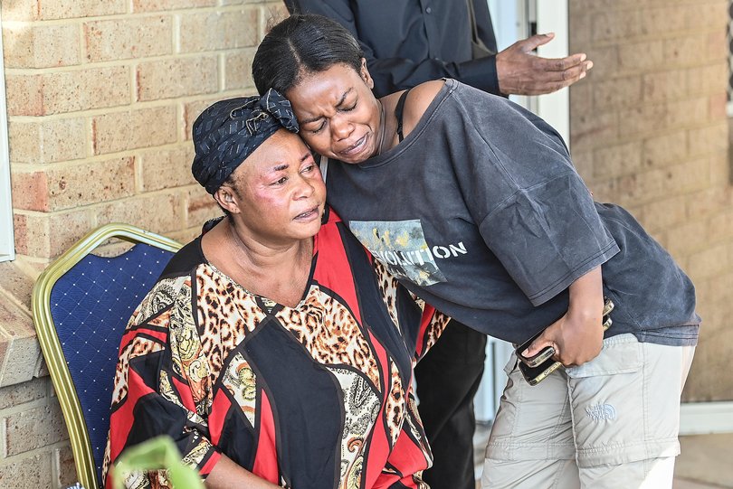 Petronia Wabiwa, the mother of Mauwa Melaniea Kizenga who was fatally stabbed in Balga on Saturday night is comforted by a supporter at her home. 