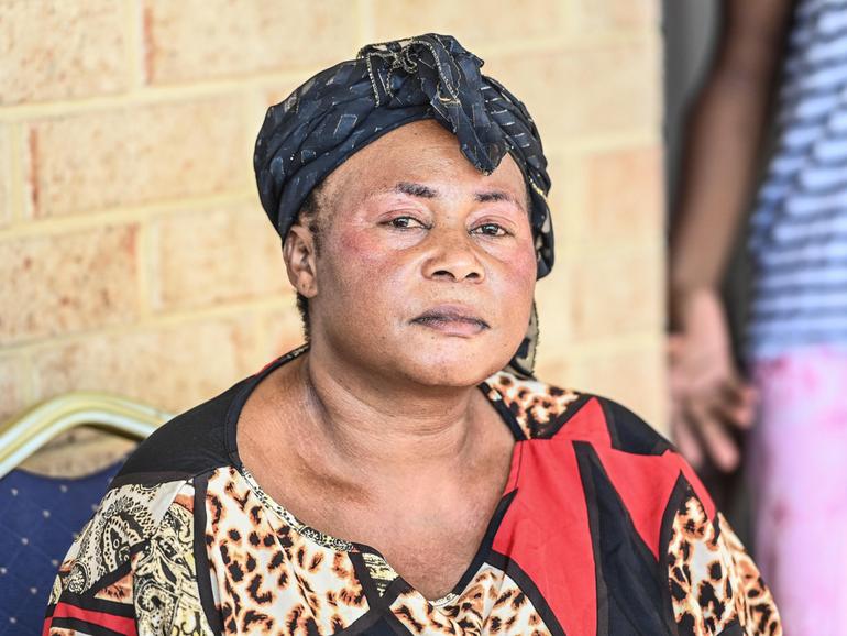Petronia Wabiwa, the mother of Mauwa Melaniea Kizenga who was fatally stabbed in Balga on Saturday night is comforted by a supporter at her home. 