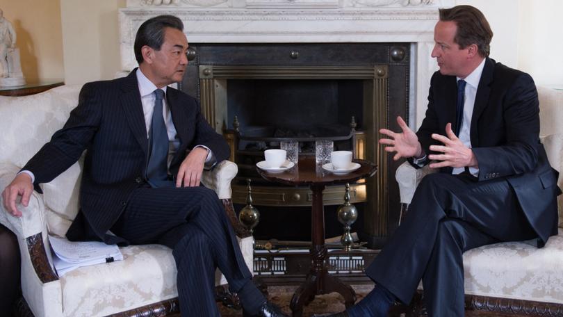 British Prime Minister David Cameron (R) talks with Chinese Foreign Minister Wang Yi.