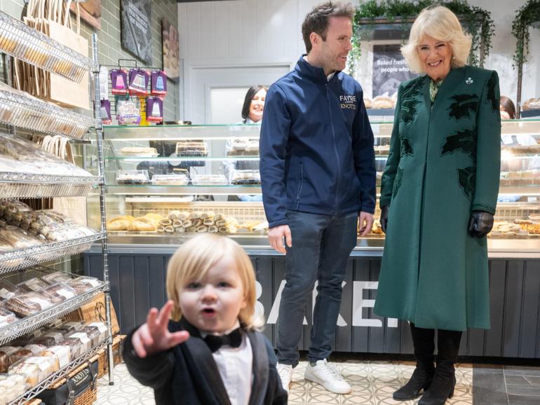 -Queen Camilla looks on at one year old Fitz William Salmon-Corrie as she visits Knotts bakery in Belfast.