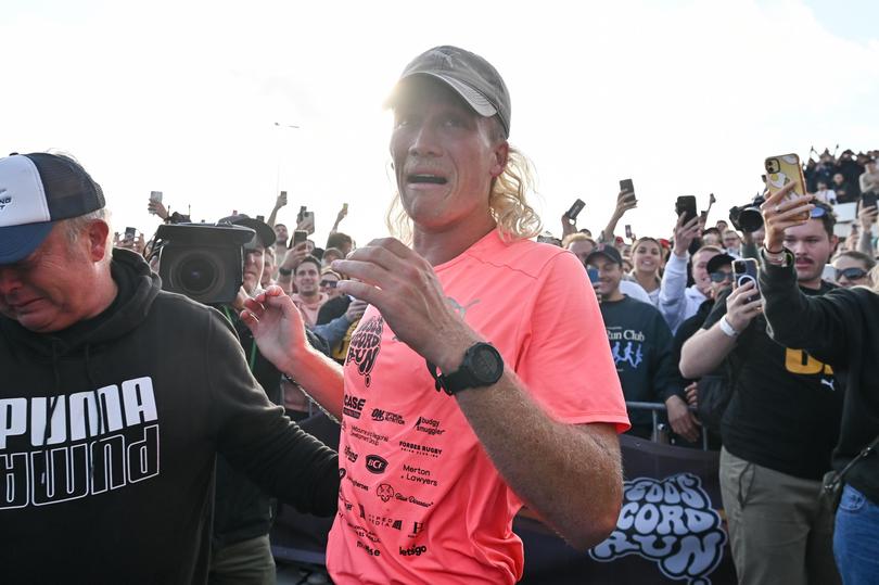 Nedd Brockmann reacts after crossing the finish line after running 4000km from Perth to Sydney, at the North Bondi Surf Life Saving Club in Sydney, Monday, October 17, 2022. 