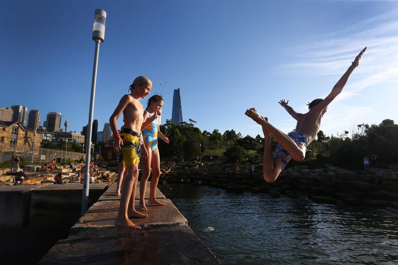Young swimmers jump into the water at Marrinawi Cove in Sydney.