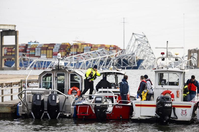 epa11244454 Rescue personnel gather on the shore of the Patapsco River after a container ship ran into the Francis Scott Key Bridge (back) causing its collapse in Baltimore, Maryland, USA, 26 March 2024. The Maryland Department of Transportation confirmed that the Francis Scott Key Bridge collapsed due to a ship strike on 26 March. According to Baltimore City Fire Department Chief James W. Wallace, a search operation was underway to locate at least seven people believed to be in the waters of the Patapsco River following the incident. 'Sonar has detected the presence of vehicles submerged in the water', Wallace added. The Singapore-flagged cargo ship DALI was traveling from Baltimore to Colombo, Sri Lanka, MarineTraffic confirmed.  EPA/JIM LO SCALZO