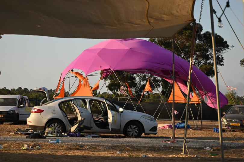 Israeli soldiers searching for ID and belongings among the cars and tents at the Supernova Music Festival site.