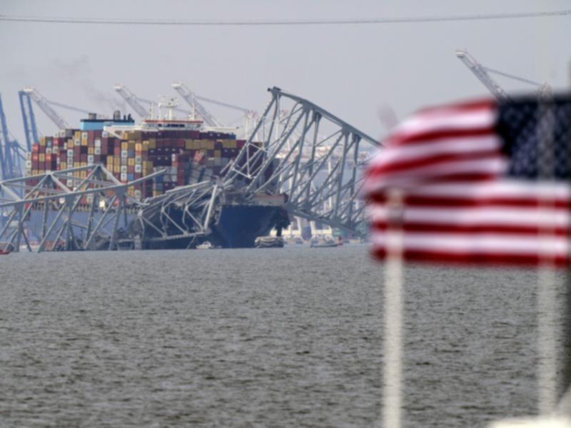 A cargo ship rests against wreckage of the Francis Scott Key Bridge