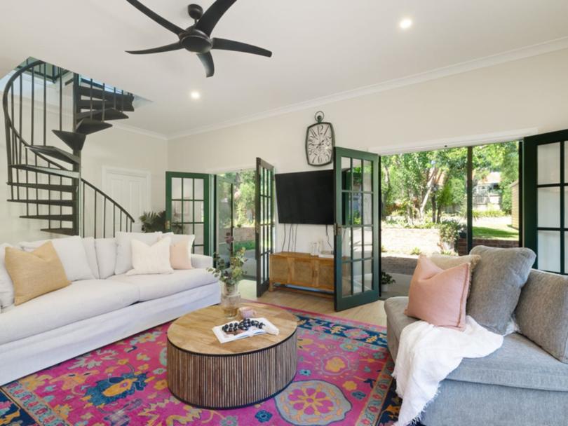 A spiral staircase in the living room leads up to a loft-style retreat and master bedroom.