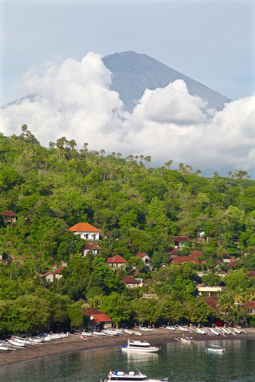 Mount Agung — Bali’s highest and holiest mountain — peeks out through the clouds.