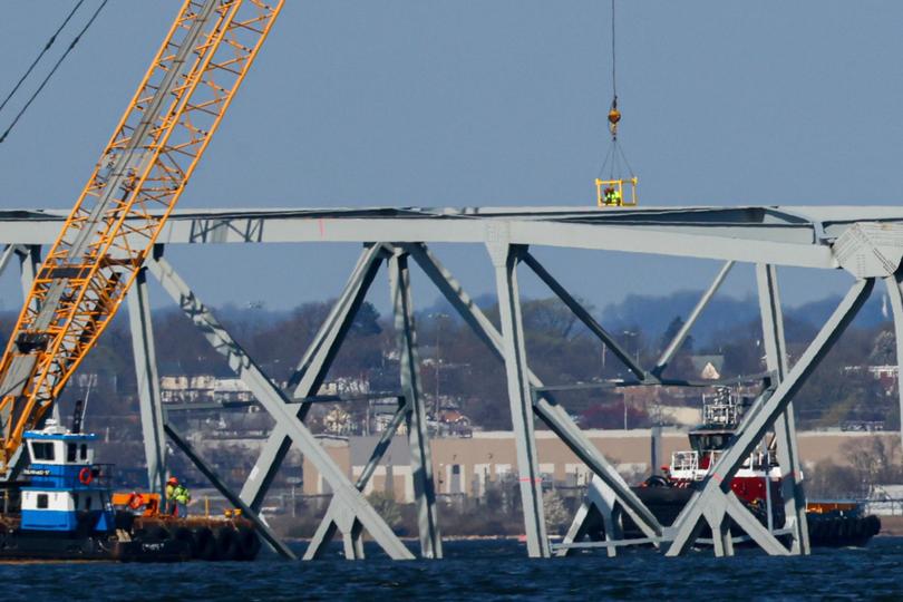 Workers in a crane-held basket mark lines on a damaged section of the Francis Scott Key Bridge, Saturday, March 30, 2024, in Baltimore, Md. (AP Photo/Julia Nikhinson) Julia Nikhinson