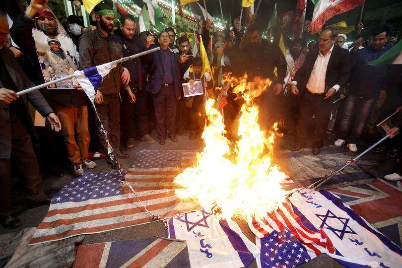 Iranians burn Israeli and US flags during a protest at Palestine square in Tehran following the airstrikes in Syria.