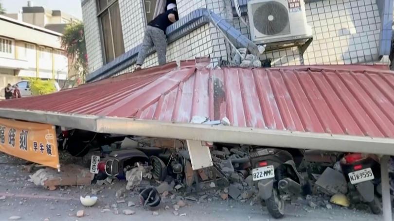 A man checks a partially collapsed building in Hualien after the 7.2 magnitude quake.