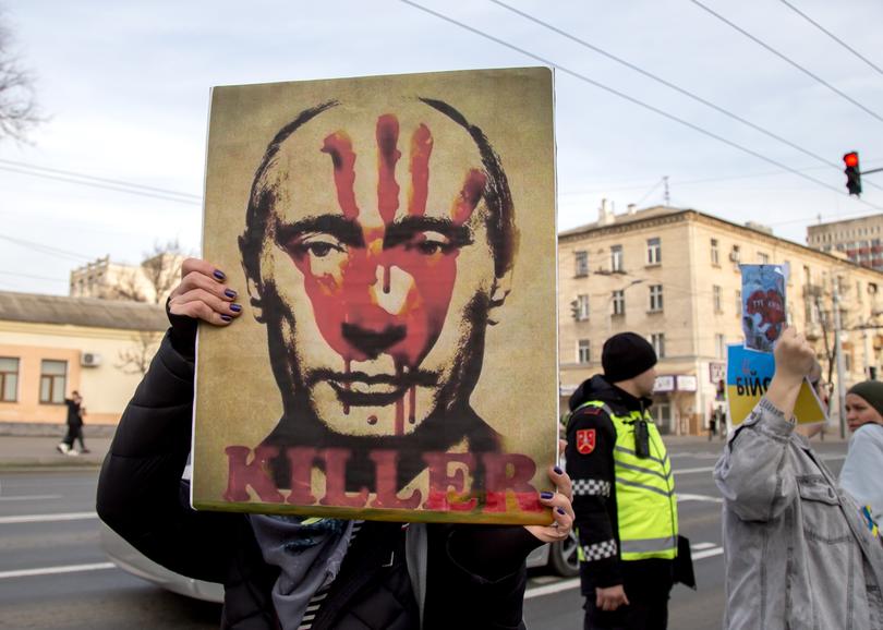 epa11179363 A woman holds a placard depicting Russian President Putin during a protest in front of the Russian embassy to mark the second anniversary of the Russian invasion of Ukraine, in Chisinau, Moldova, 24 February 2024. Russian troops entered Ukrainian territory on 24 February 2022, starting a conflict that has provoked destruction and a humanitarian crisis.  EPA/DUMITRU DORU