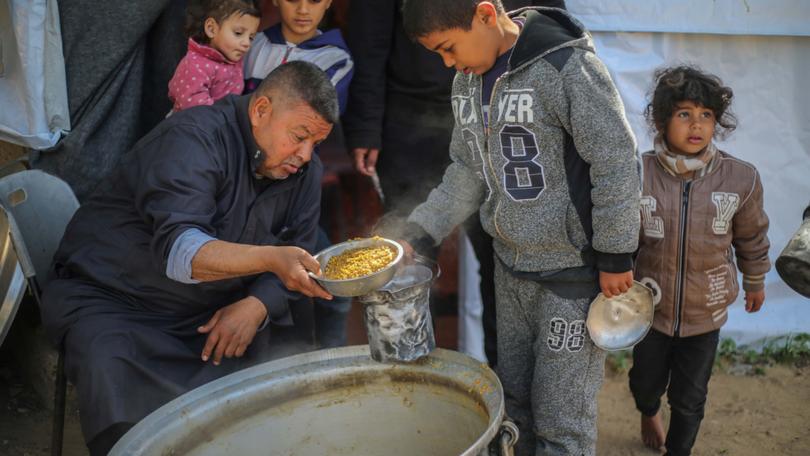 Children queue for food in Rafah.