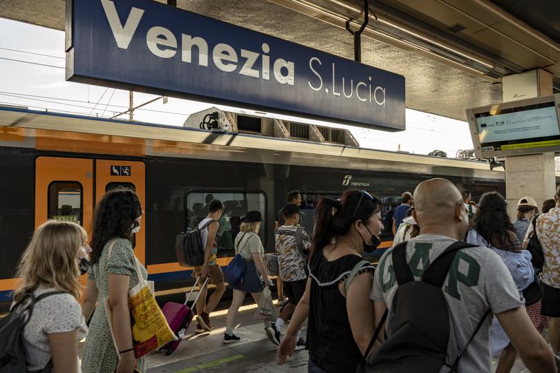 Commuters at Santa Lucia train station in Venice, Italy, Aug. 9, 2022. Under the new measures, after registering on a website, visitors will receive a QR code to show when entering the city. 