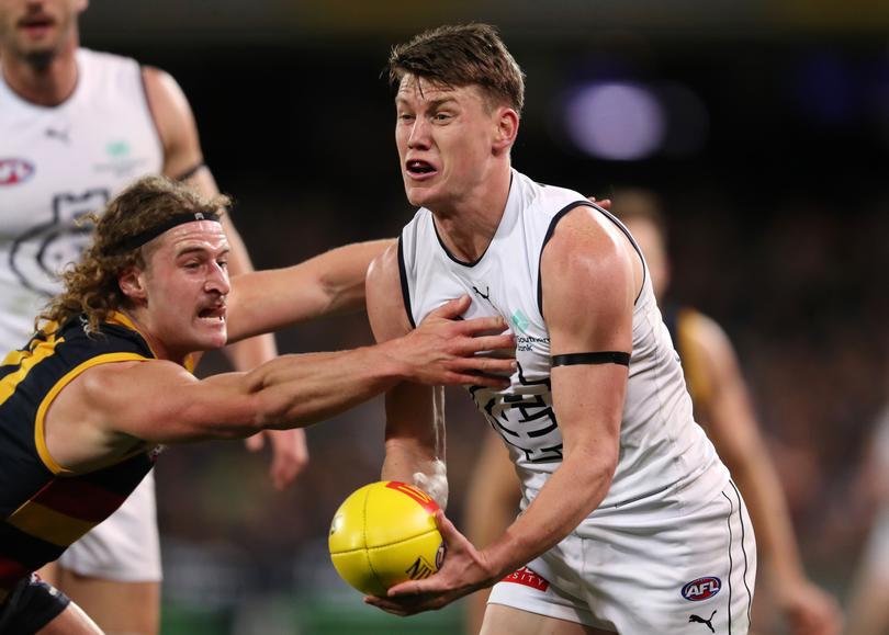 ADELAIDE, AUSTRALIA - JULY 30: Sam Walsh of the Blues handpasses the ball away from Sam Berry of the Crows during the 2022 AFL Round 20 match between the Adelaide Crows and the Carlton Blues at the Adelaide Oval on July 30, 2022 in Adelaide, Australia. (Photo by Sarah Reed/AFL Photos)