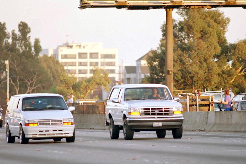 Al Cowlings, with O.J. Simpson hiding, drives a white Ford Bronco as they lead police on a two-county chase.