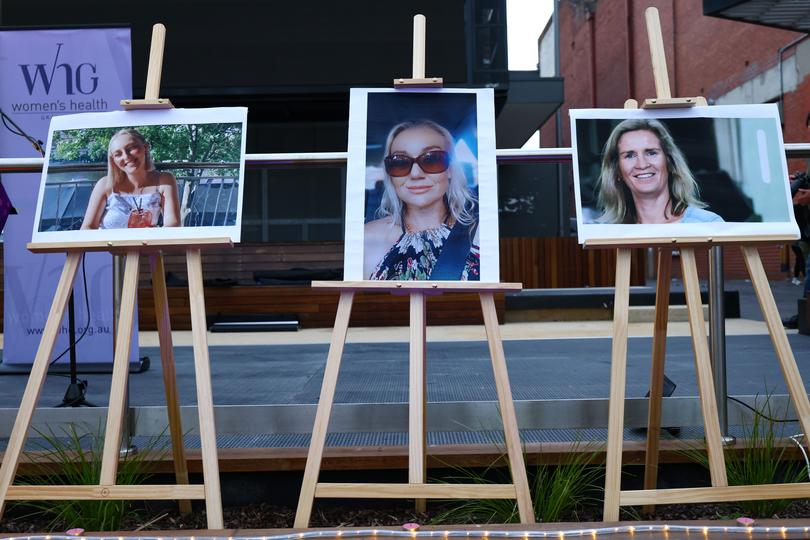 Photos of recent victims are seen on display where members of the Ballarat community participate in a rally against men's violence. 