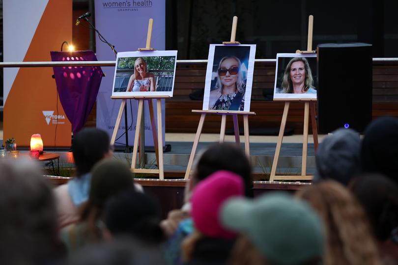 Photos of recent victims are seen on display where members of the Ballarat community participate in a rally against men's violence.