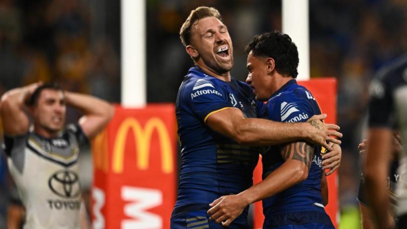 Bryce Cartwright (left) congratulates Daejarn Asi on his match-clinching try for the Eels. (James Gourley/AAP PHOTOS)