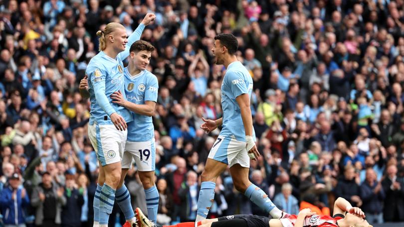 Erling Haaland, Julian Alvarez and Matheus Nunes of Manchester City celebrate their team's first goal, an own-goal scored by Daiki Hashioka of Luton Town.