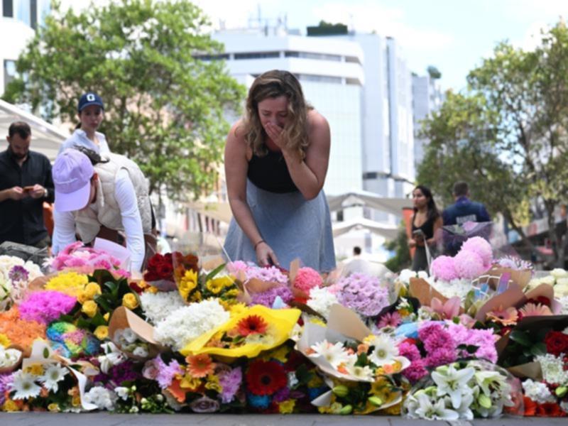 People lay flowers at the scene of the mass stabbing at Bondi Junction