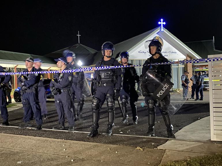 A witness has recounted the terrifying moment a church was swarmed by rioters after a Bishop was allegedly stabbed during a Monday night mass.