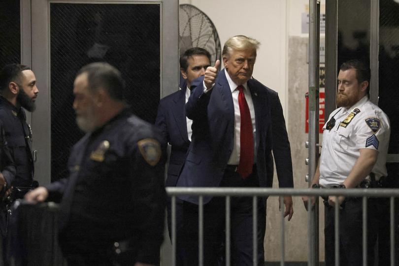 Former President Donald Trump gives a thumbs-up outside the courtroom as he returns from a lunch break. (Jefferson Siegel/The New York Times)