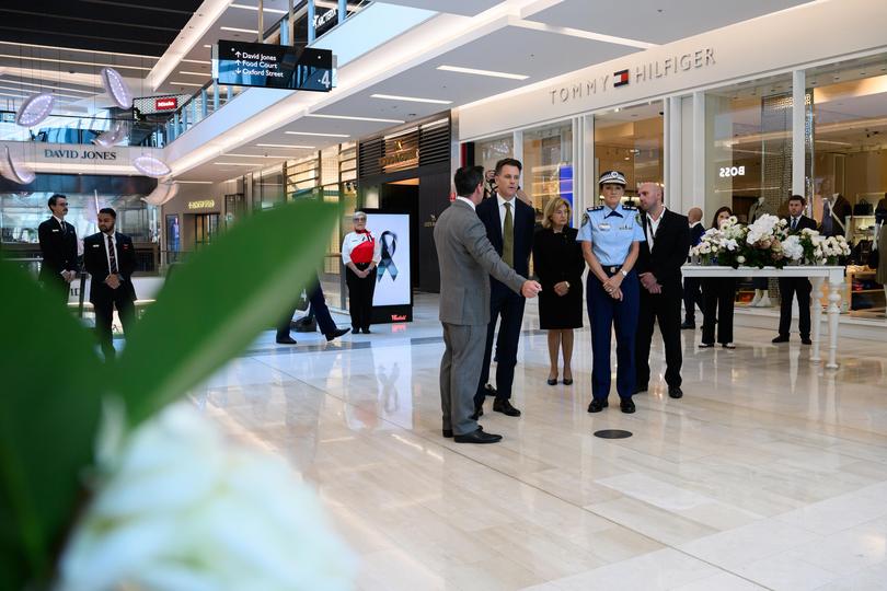 Scentre Group Chief Executive Elliott Rusanow (left), NSW Premier Chris Minns (centre) and NSW Police Commissioner Karen Webb (second right) visit the memorial to the victims.