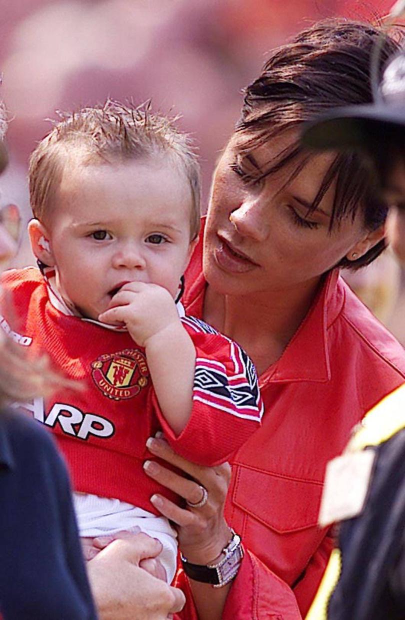 Victoria Beckham and her son Brooklyn watch his father David lift the English Premier League soccer trophy at Old Trafford, Manchester, England, Saturday, May 6, 2000.