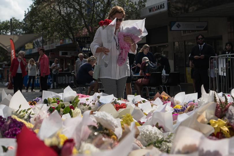 People leave floral tributes for the victims of the stabbing attack at the Westfield Bondi Junction shopping centre in Sydney, Wednesday, April 17, 2024. 
