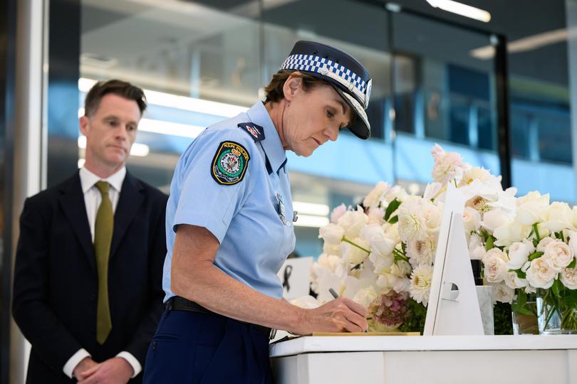 NSW Premier Chris Minns (L), and NSW Police Commissioner Karen Webb sign a condolence book whilst visiting a memorial to the victims who lost their lives in Saturday's knife attack at Westfield Bondi Junction on April 18, 2024, in Bondi Junction, Australia.  