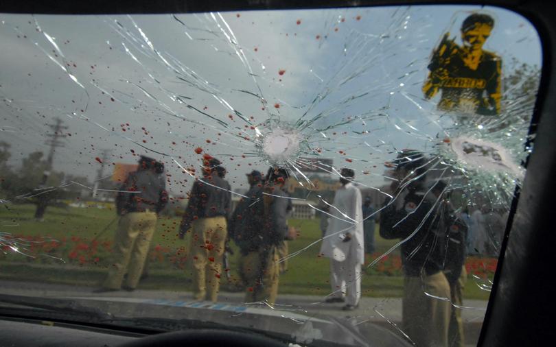 Pakistani policemen gather beside the wreckage of a police van after masked gunmen attacked the Sri Lankan cricket team in Lahore on March 3, 2009. 