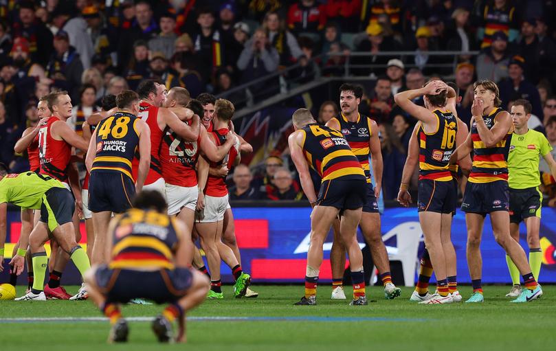 ADELAIDE, AUSTRALIA - APRIL 19: Players react on the siren with Essendon celebrating and Crows player slump after the loss during the 2024 AFL Round 06 match between the Adelaide Crows and the Essendon Bombers at Adelaide Oval on April 19, 2024 in Adelaide, Australia. (Photo by Sarah Reed/AFL Photos via Getty Images)