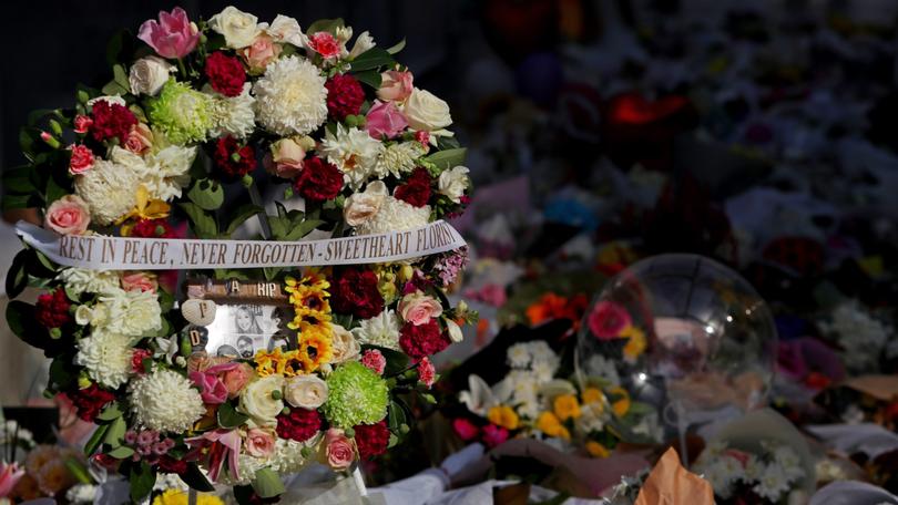 Flower tributes and condolence messages are seen at the edge of Westfield Bondi Junction during a day of reflection on April 18, 2024, in Bondi Junction, Australia. 