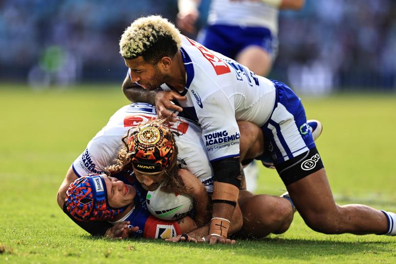 Kalyn Ponga is tackled by Viliame Kikau and Josh Curran.