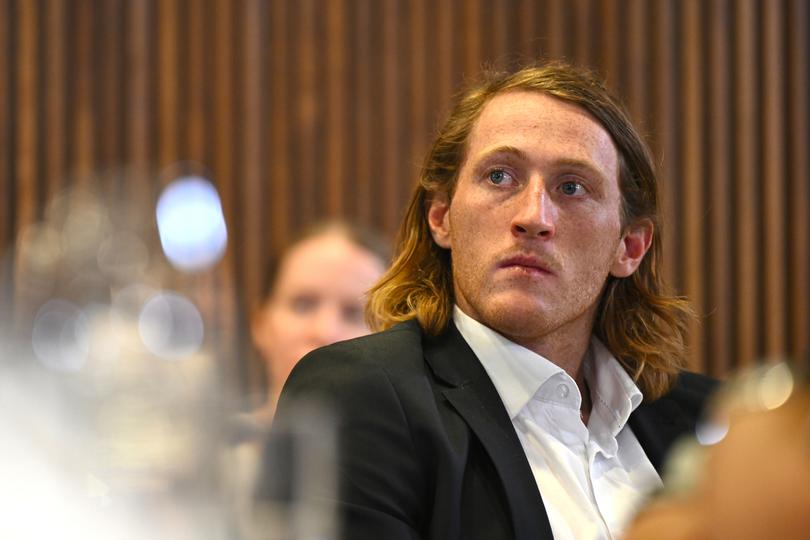 Medically retired AFL player Nathan Murphy listens to Wally Lewis address the National Press Club.