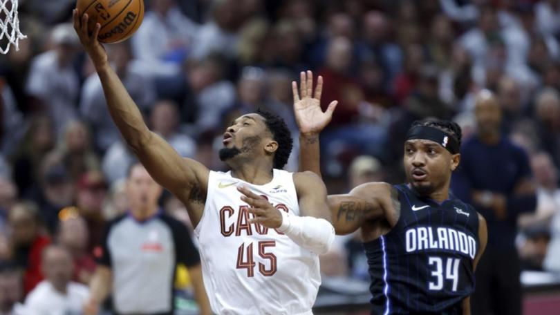 Cleveland's Donovan Mitchell (45) shoots against Orlando Magic's Wendell Carter Jr. (AP PHOTO)