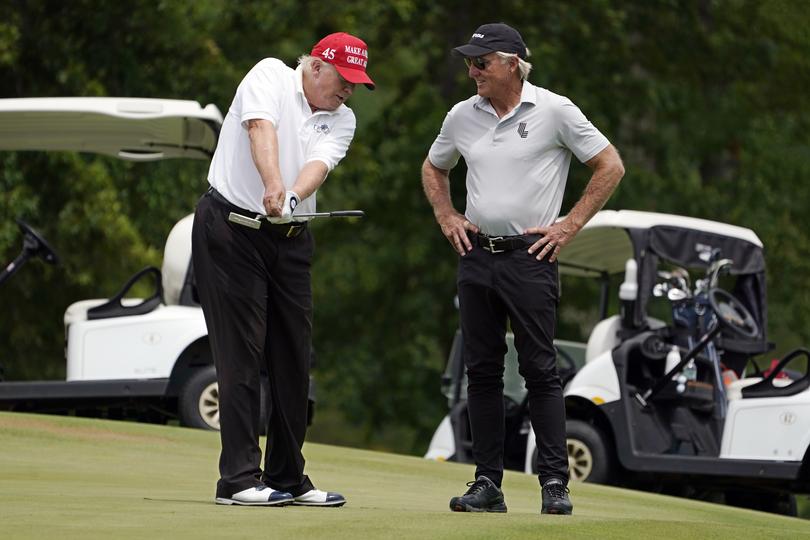 Former President Donald Trump, left, talks with LIV Golf CEO Greg Norman on a green during the pro-am round of the Bedminster Invitational LIV Golf tournament in Bedminster, NJ., Thursday, July 28, 2022. (AP Photo/Seth Wenig)