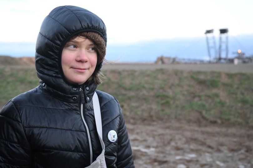 Climate activist Greta Thunberg stands between Keyenberg and Lützerath on the edge of the open pit mine. 