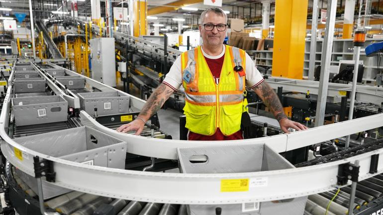 Amazon employee Andrew Clark controls the packages being scanned for delivery at the Kemps Creek Amazon Fulfilment Centre in Sydney. 