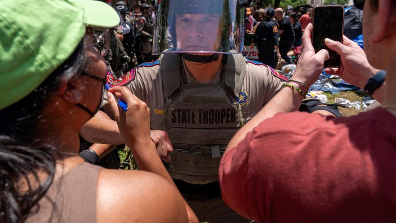 Pro-Palestinian protestors confront a Texas State trooper at the University of Texas in Austin, Texas, on April 29, 2024. - The protests against Israel's war with Hamas began at Columbia University earlier this month before spreading to campuses across the country. They have posed a major challenge to university administrators who are trying to balance campus commitments to free expression with complaints that the rallies have crossed a line. (Photo by SUZANNE CORDEIRO / AFP)