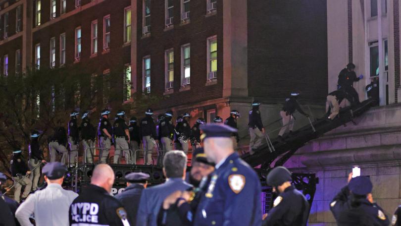 NYPD officers in riot gear break into a building at Columbia University, where pro-Palestinian students are barricaded inside a building